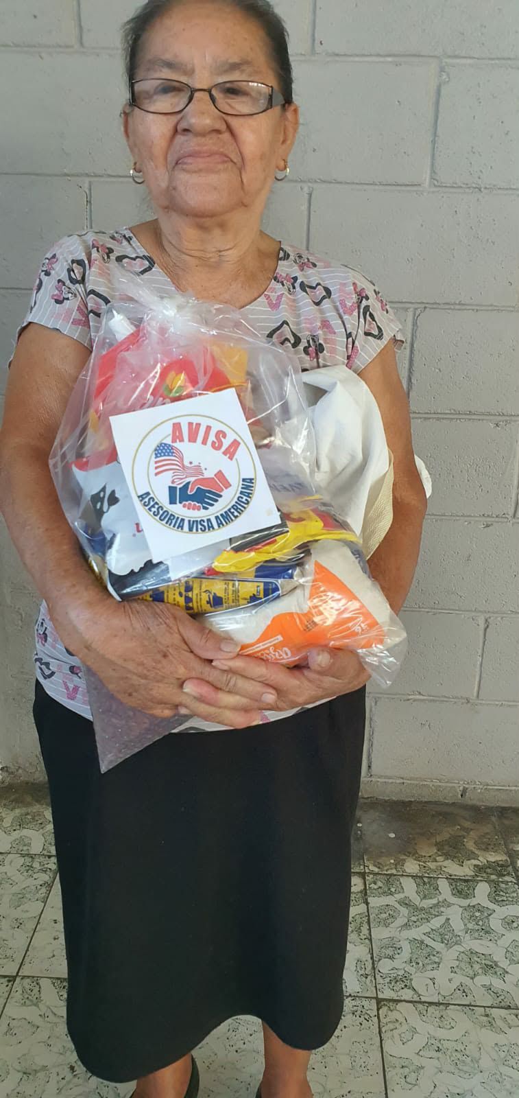 Recipient holding a food package outside a home