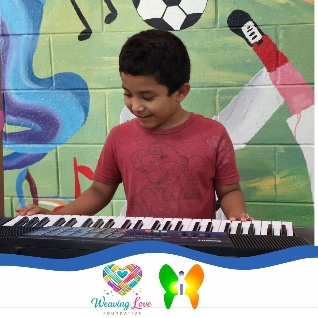 Young child practicing at a keyboard in a classroom