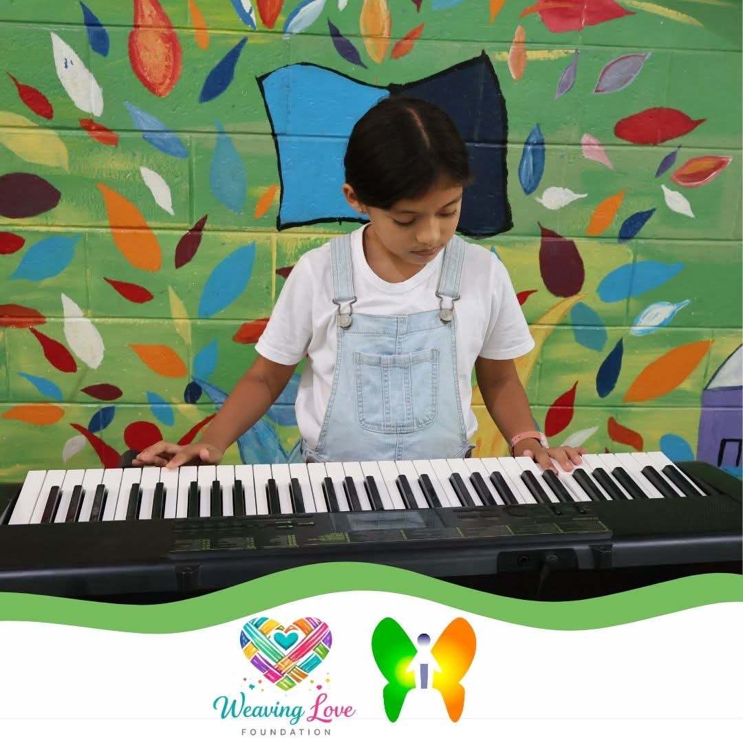 Girl smiling beside a keyboard during class