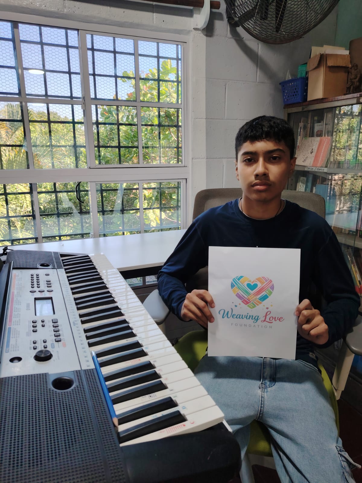 Teen holding a foundation page beside a keyboard